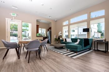 A living room with a wooden floor and a green sofa.